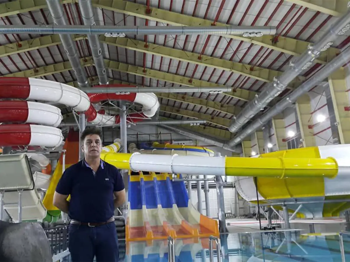 Indoor water park design with colorful water slides under a covered roof